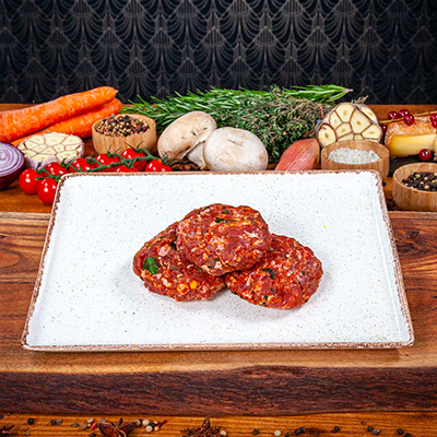 3 BOULETTES DE KEFTA DE BOEUF CRUES PRÉSENTÉES DANS UNE ASSIETTE