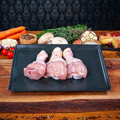 3 PILONS DE POULET CRUS PRÉSENTÉS SUR UNE ASSIETTE