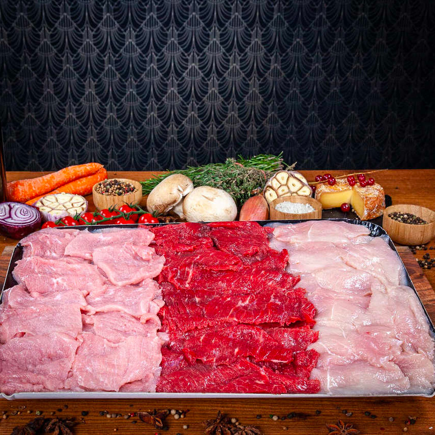 Un plateau de viande crue nature de poulet, veau et boeuf coupé en tranches