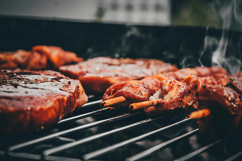 des brochettes et grillades en train de cuire sur un barbecue