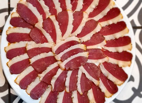 des tranches de magret de canard fumé sur une assiette