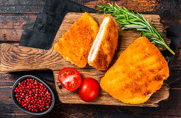 un cordon bleu fondant sur une planche en bois coupé en deux