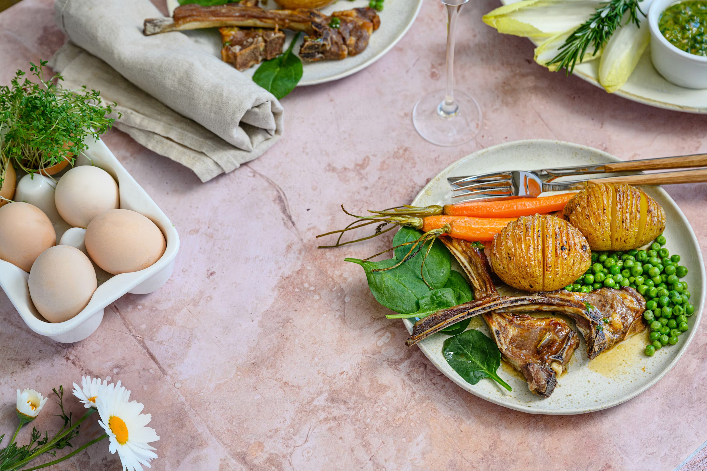 Deux côtes d'agneau dans une assiettes blanche avec des petits pois pour pâques