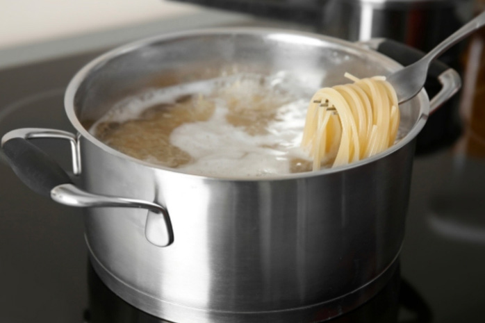 des spaghettis qui cuisent dans un faitout en inox