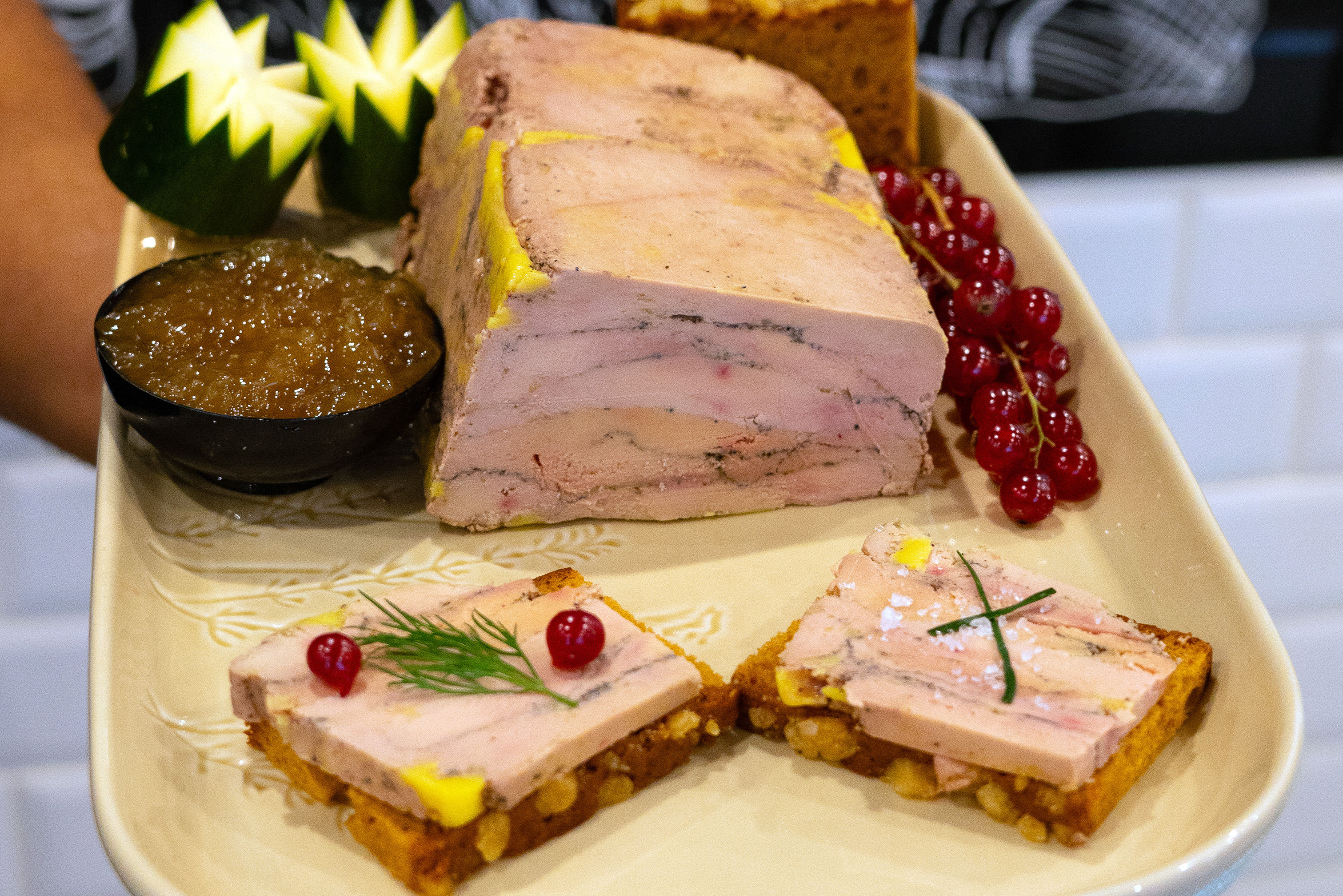 Un fois gras maison préparé par un boucher présenté sur une assiette vec du pain d'épices