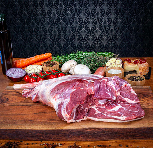 une gigot d'agneau cru sur un table en bois