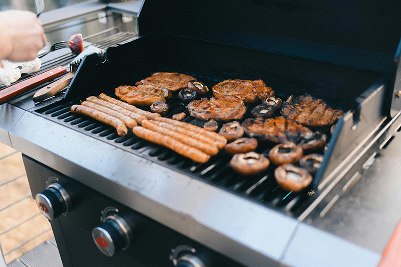 des grillades en train de cuire sur un barbecue à gaz