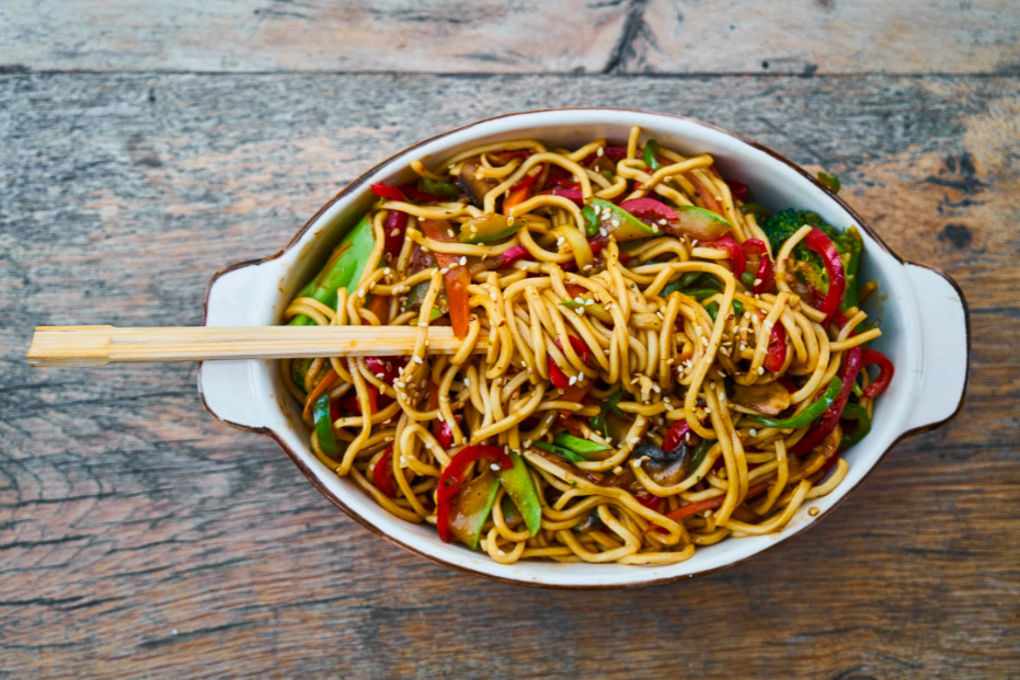 Des nouilles chinoises cuisinées avec des légumes sautés présentés dans un plat