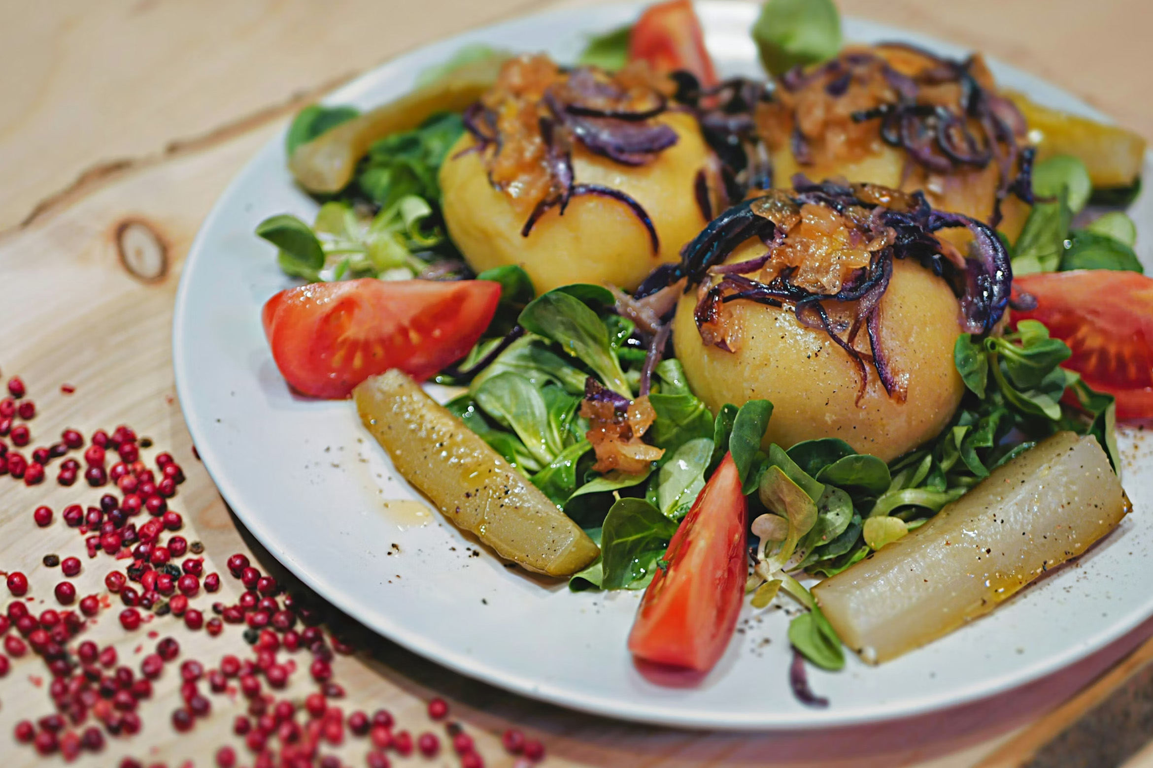 des pommes de terre au four dans une assiette accompagnées de mâche et tomates