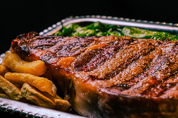 Une entrecôte maturée dans une assiette accompagnée de frites