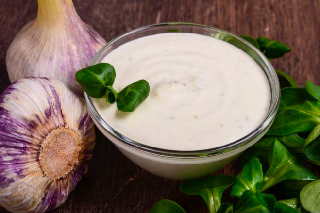 Une sauce blanche à l'ail dans un bol en verre