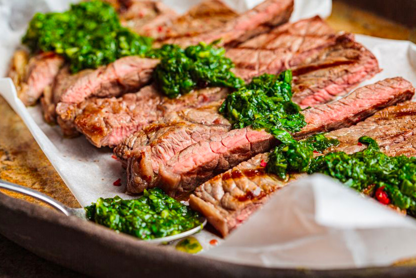Une bavette de boeuf tranchée recouverte d'une sauce chimichuri