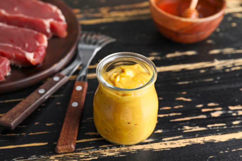 Une sauce moutarde et miel dans un pot de yaourt en verre