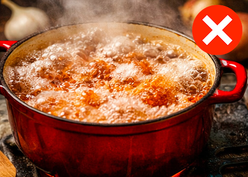 une cocotte avec de la viande à mijoter en train de bouillir et faire des bulles