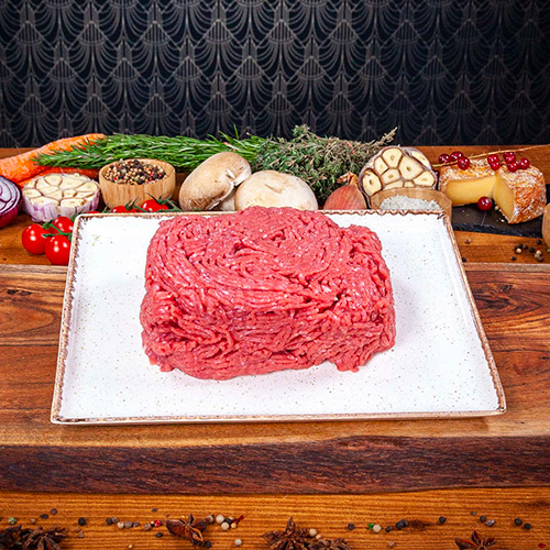 de la viande hachée de boeuf crue présentée dans une assiette