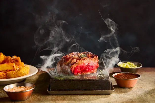 Une pièce de boeuf qui cuit sur une pierrade