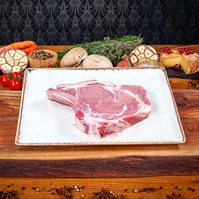 Une côte de veau brute posée sur une planche en bois