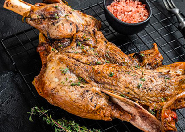 Une epaule d'agneau quire sur une grille au barbecue