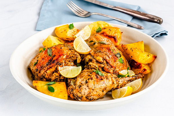 3 cuisses de poulet rôties avec du citron et du miel sevies dans une assiette