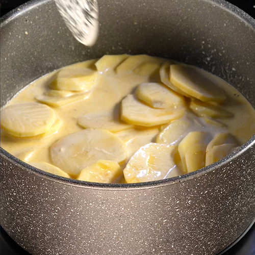 Des pommes de terre en plein cuisson dans du mait et de la crème dans une cocotte