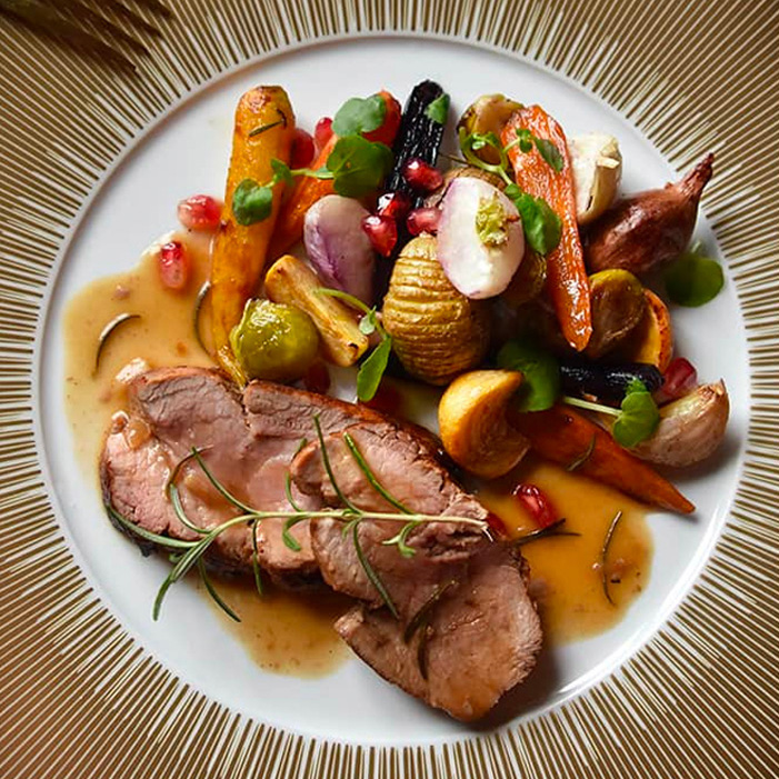Une tranche de filet mignon de veau avec une sauce à l'estragon et des légumes nouveaux