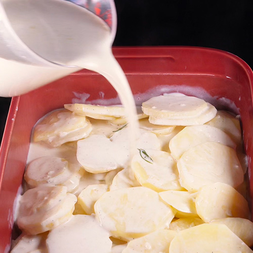 Un plat dans lequel on verse de la crème pour un gratin dauphinois