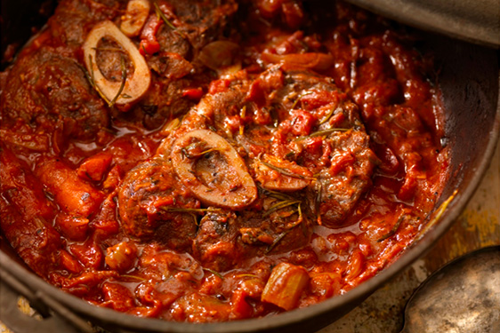 Un recette d'osso bucco de veau à la sauce tomate servie dans une cocotte