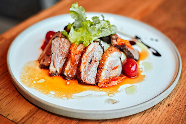 Une magret de canard coupé en tranche présenté dans une assiette