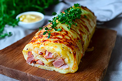 Un roulé de pommes de terre avec du jambon de veau en cubes dedans