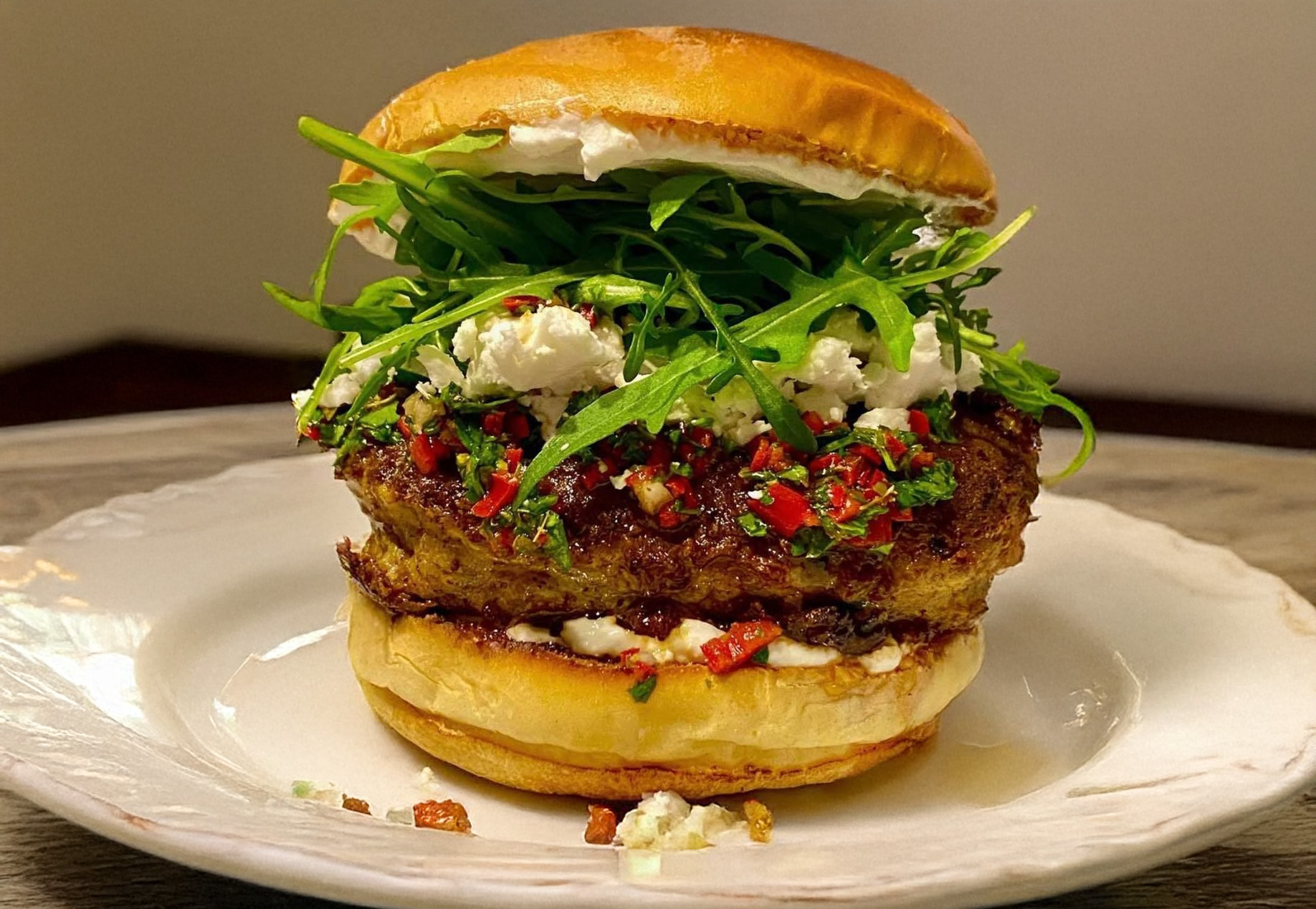 un burger avec de la viande d'agneau et une sauce chimichurri